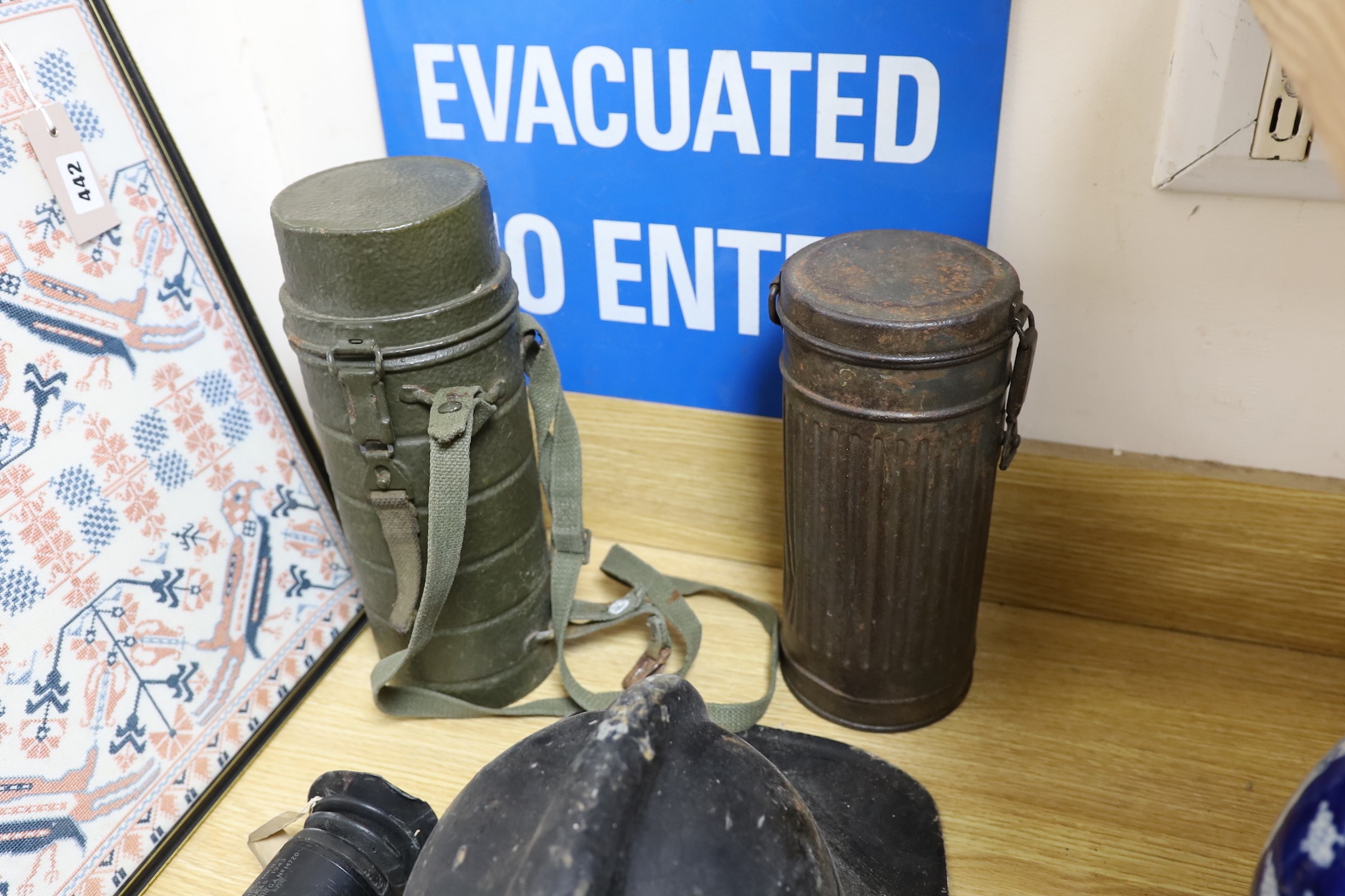 A WW2 gas mask in original metal case, together with other related ephemera, including an enamelled sign, a fire brigade hat, etc.
